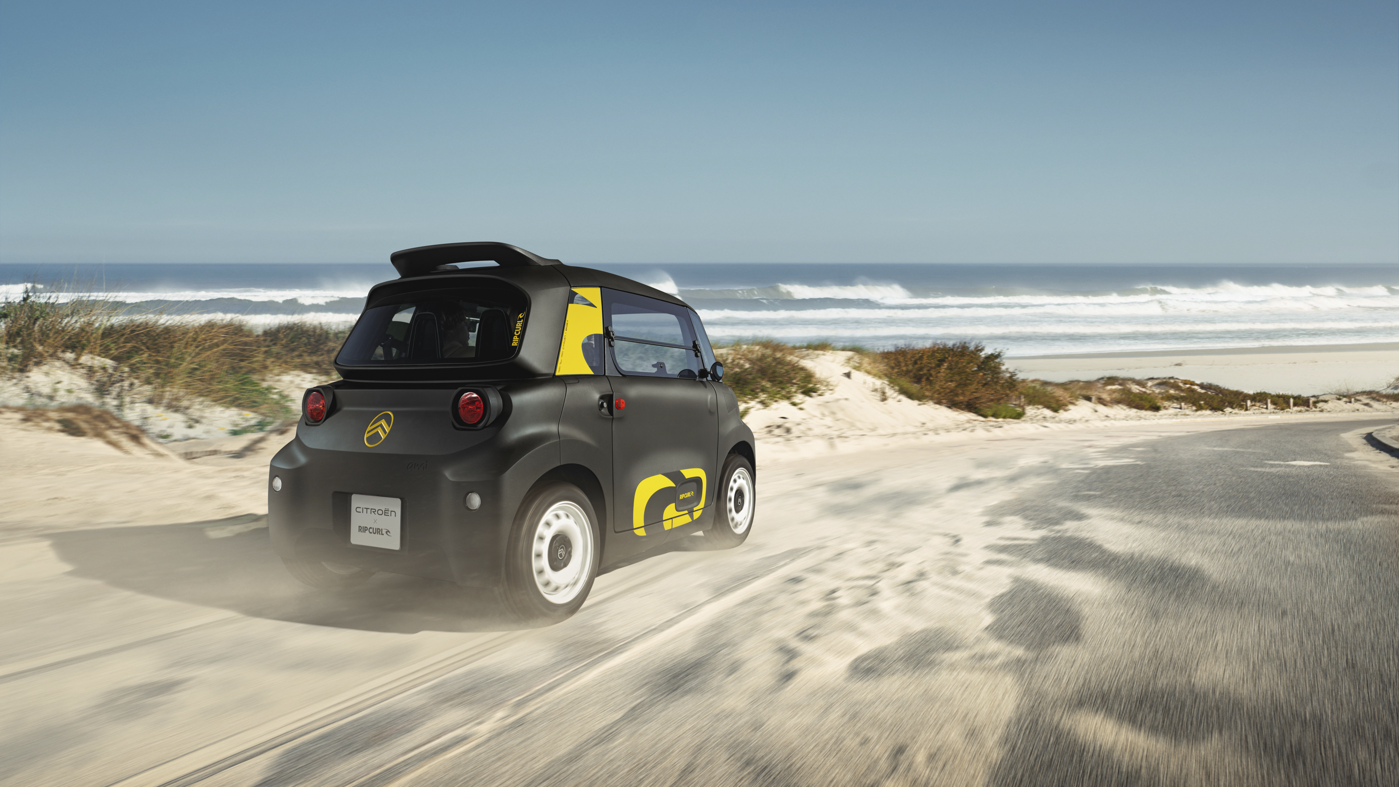 Vue arrière de trois quarts de la Citroën Ami x Rip Curl électrique sans permis, la liberté de la Citroën Ami pour la voiture électrique urbaine