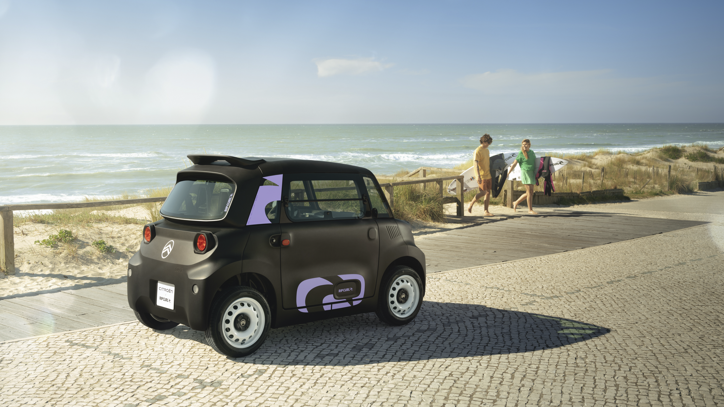 Vue arrière de trois quarts de la Citroën Ami x Rip Curl électrique sans permis, la liberté côtière de la Citroën Ami pour une voiture électrique urbaine